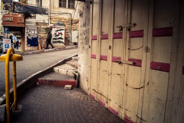 Hebron, Batı Şeria, 30 Ocak 2026 kapalı dükkan kepenkleri ve Hebron şehrinin caddesinde çift taraflı metal kapılar. Cuma günkü ticari kapanma sembolleri.