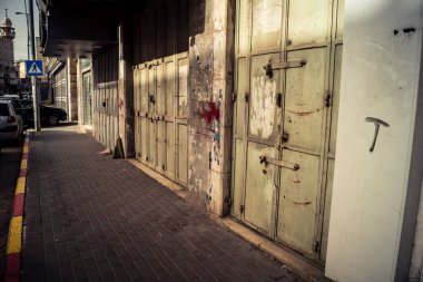 Hebron, Batı Şeria, 30 Ocak 2026 kapalı dükkan kepenkleri ve Hebron şehrinin caddesinde çift taraflı metal kapılar. Cuma günkü ticari kapanma sembolleri.