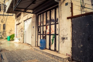 Hebron, Batı Şeria, 30 Ocak 2026 kapalı dükkan kepenkleri ve Hebron şehrinin caddesinde çift taraflı metal kapılar. Cuma günkü ticari kapanma sembolleri.