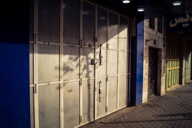 Hebron, Batı Şeria, 30 Ocak 2026 kapalı dükkan kepenkleri ve Hebron şehrinin caddesinde çift taraflı metal kapılar. Cuma günkü ticari kapanma sembolleri.