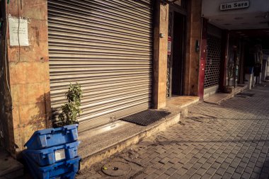 Hebron, Batı Şeria, 30 Ocak 2026 kapalı dükkan kepenkleri ve Hebron şehrinin caddesinde çift taraflı metal kapılar. Cuma günkü ticari kapanma sembolleri.