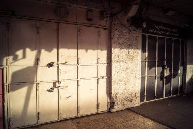 Hebron, Batı Şeria, 30 Ocak 2026 kapalı dükkan kepenkleri ve Hebron şehrinin caddesinde çift taraflı metal kapılar. Cuma günkü ticari kapanma sembolleri.