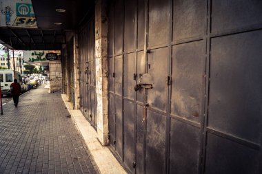 Hebron, Batı Şeria, 30 Ocak 2026 kapalı dükkan kepenkleri ve Hebron şehrinin caddesinde çift taraflı metal kapılar. Cuma günkü ticari kapanma sembolleri.