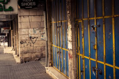 Hebron, Batı Şeria, 30 Ocak 2026 kapalı dükkan kepenkleri ve Hebron şehrinin caddesinde çift taraflı metal kapılar. Cuma günkü ticari kapanma sembolleri.