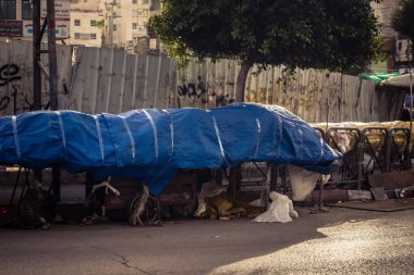 Hebron, Batı Şeria, 30 Ocak 2026. El Halil 'in merkezindeki haftalık kapanış sırasında plastik muşamba kaplı sokak satıcısı ve market tezgahları..