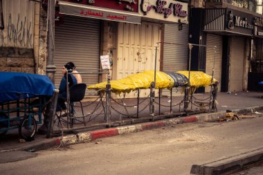 Hebron, Batı Şeria, 30 Ocak 2026. El Halil 'in merkezindeki haftalık kapanış sırasında plastik muşamba kaplı sokak satıcısı ve market tezgahları..