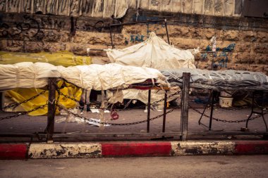 Hebron, Batı Şeria, 30 Ocak 2026. El Halil 'in merkezindeki haftalık kapanış sırasında plastik muşamba kaplı sokak satıcısı ve market tezgahları..