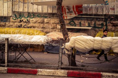 Hebron, Batı Şeria, 30 Ocak 2026. El Halil 'in merkezindeki haftalık kapanış sırasında plastik muşamba kaplı sokak satıcısı ve market tezgahları..