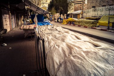 Hebron, Batı Şeria, 30 Ocak 2026. El Halil 'in merkezindeki haftalık kapanış sırasında plastik muşamba kaplı sokak satıcısı ve market tezgahları..