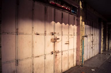 Hebron, Batı Şeria, 30 Ocak 2026 kapalı dükkan kepenkleri ve Hebron şehrinin caddesinde çift taraflı metal kapılar. Cuma günkü ticari kapanma sembolleri.