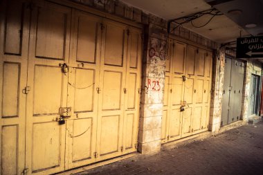 Hebron, Batı Şeria, 30 Ocak 2026 kapalı dükkan kepenkleri ve Hebron şehrinin caddesinde çift taraflı metal kapılar. Cuma günkü ticari kapanma sembolleri.