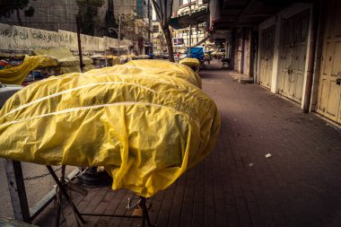 Hebron, Batı Şeria, 30 Ocak 2026. El Halil 'in merkezindeki haftalık kapanış sırasında plastik muşamba kaplı sokak satıcısı ve market tezgahları..