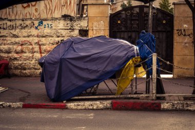 Hebron, Batı Şeria, 30 Ocak 2026. El Halil 'in merkezindeki haftalık kapanış sırasında plastik muşamba kaplı sokak satıcısı ve market tezgahları..