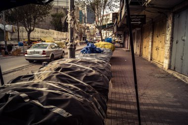 Hebron, Batı Şeria, 30 Ocak 2026. El Halil 'in merkezindeki haftalık kapanış sırasında plastik muşamba kaplı sokak satıcısı ve market tezgahları..