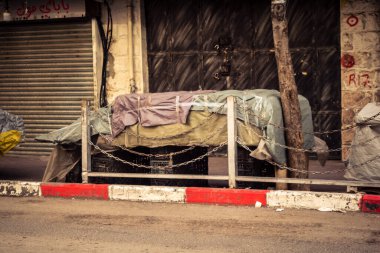 Hebron, Batı Şeria, 30 Ocak 2026. El Halil 'in merkezindeki haftalık kapanış sırasında plastik muşamba kaplı sokak satıcısı ve market tezgahları..