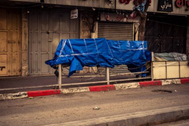 Hebron, Batı Şeria, 30 Ocak 2026. El Halil 'in merkezindeki haftalık kapanış sırasında plastik muşamba kaplı sokak satıcısı ve market tezgahları..