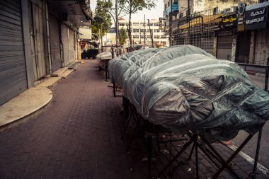 Hebron, Batı Şeria, 30 Ocak 2026. El Halil 'in merkezindeki haftalık kapanış sırasında plastik muşamba kaplı sokak satıcısı ve market tezgahları..