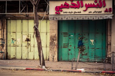 Hebron, Batı Şeria, 30 Ocak 2026 kapalı dükkan kepenkleri ve Hebron şehrinin caddesinde çift taraflı metal kapılar. Cuma günkü ticari kapanma sembolleri.