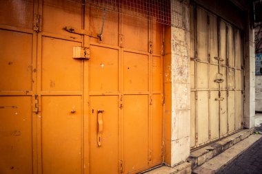 Hebron, Batı Şeria, 30 Ocak 2026 kapalı dükkan kepenkleri ve Hebron şehrinin caddesinde çift taraflı metal kapılar. Cuma günkü ticari kapanma sembolleri.