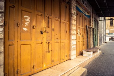 Hebron, Batı Şeria, 30 Ocak 2026 kapalı dükkan kepenkleri ve Hebron şehrinin caddesinde çift taraflı metal kapılar. Cuma günkü ticari kapanma sembolleri.