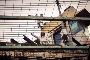 Hebron, Filistin Bölgesi, 31 Ocak 2026 Dikey Ayrımcılık. Üst katlardaki İsrailli göçmen çocuklar Filistin sokaklarına bakıyor. Metal ağ pazarı fırlatılan nesnelerden korur.