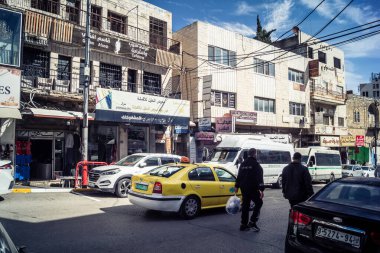 Hebron, Batı Şeria, 7 Şubat 2026 Vibrant sokak yaşamı ve Filistin 'deki El Halil' in merkezindeki işlek pazarlar. Sarı taksiler ve kalabalık kalabalık kalabalık işlek caddelerde geziniyor..