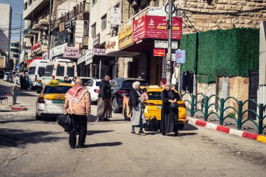 Hebron, Batı Şeria, 7 Şubat 2026 Vibrant sokak yaşamı ve Filistin 'deki El Halil' in merkezindeki işlek pazarlar. Sarı taksiler ve kalabalık kalabalık kalabalık işlek caddelerde geziniyor..