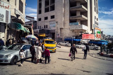 Hebron, Batı Şeria, 7 Şubat 2026 Vibrant sokak yaşamı ve Filistin 'deki El Halil' in merkezindeki işlek pazarlar. Sarı taksiler ve kalabalık kalabalık kalabalık işlek caddelerde geziniyor..