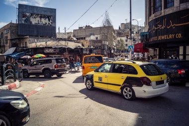 Hebron, Batı Şeria, 7 Şubat 2026 Vibrant sokak yaşamı ve Filistin 'deki El Halil' in merkezindeki işlek pazarlar. Sarı taksiler ve kalabalık kalabalık kalabalık işlek caddelerde geziniyor..