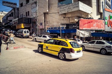 Hebron, Batı Şeria, 7 Şubat 2026 Vibrant sokak yaşamı ve Filistin 'deki El Halil' in merkezindeki işlek pazarlar. Sarı taksiler ve kalabalık kalabalık kalabalık işlek caddelerde geziniyor..