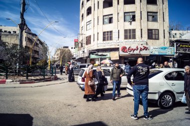 Hebron, Batı Şeria, 7 Şubat 2026 Vibrant sokak yaşamı ve Filistin 'deki El Halil' in merkezindeki işlek pazarlar. Sarı taksiler ve kalabalık kalabalık kalabalık işlek caddelerde geziniyor..