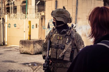 Hebron, Filistin Toprakları, 7 Şubat 2026 İsrail askerleri (IDF) taktik teçhizat ile bir grup Yahudi yerleşimciye H2 bölünmüş bölgede, Eski Şehir sokaklarında eşlik ederler..