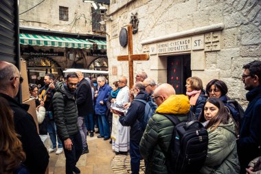 Kudüs, İsrail, 19 Şubat 2026 'da bir papazın yönettiği İtalyan Hristiyan hacılar Eski Şehir Via Dolorosa boyunca resmi bir geçit töreni düzenledi. Dindarlar dar sokaklarda haç taşır.