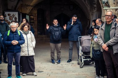Kudüs, İsrail, 19 Şubat 2026 'da bir papazın yönettiği İtalyan Hristiyan hacılar Eski Şehir Via Dolorosa boyunca resmi bir geçit töreni düzenledi. Dindarlar dar sokaklarda haç taşır.