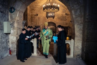 Kudüs, İsrail, 21 Şubat 2026 Katolik rahipler ve inananlar Kutsal Mezar 'ın karanlığında bir ayini kutluyorlar. Antik şehir tapınağındaki kutsal dua ve inanç atmosferi.