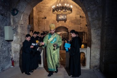 Kudüs, İsrail, 21 Şubat 2026 Katolik rahipler ve inananlar Kutsal Mezar 'ın karanlığında bir ayini kutluyorlar. Antik şehir tapınağındaki kutsal dua ve inanç atmosferi.