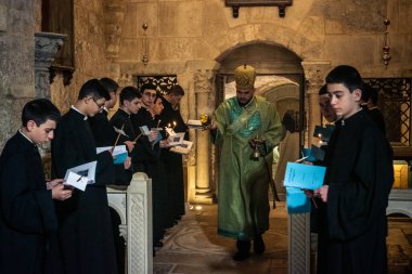 Kudüs, İsrail, 21 Şubat 2026 Katolik rahipler ve inananlar Kutsal Mezar 'ın karanlığında bir ayini kutluyorlar. Antik şehir tapınağındaki kutsal dua ve inanç atmosferi.