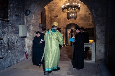 Kudüs, İsrail, 21 Şubat 2026 Katolik rahipler ve inananlar Kutsal Mezar 'ın karanlığında bir ayini kutluyorlar. Antik şehir tapınağındaki kutsal dua ve inanç atmosferi.