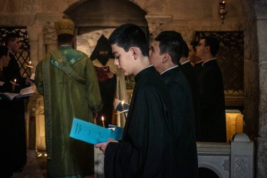 Kudüs, İsrail, 21 Şubat 2026 Katolik rahipler ve inananlar Kutsal Mezar 'ın karanlığında bir ayini kutluyorlar. Antik şehir tapınağındaki kutsal dua ve inanç atmosferi.