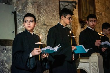 Kudüs, İsrail, 21 Şubat 2026 Katolik rahipler ve inananlar Kutsal Mezar 'ın karanlığında bir ayini kutluyorlar. Antik şehir tapınağındaki kutsal dua ve inanç atmosferi.