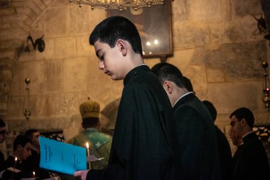 Kudüs, İsrail, 21 Şubat 2026 Katolik rahipler ve inananlar Kutsal Mezar 'ın karanlığında bir ayini kutluyorlar. Antik şehir tapınağındaki kutsal dua ve inanç atmosferi.