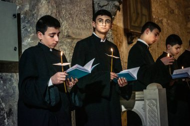 Kudüs, İsrail, 21 Şubat 2026 Katolik rahipler ve inananlar Kutsal Mezar 'ın karanlığında bir ayini kutluyorlar. Antik şehir tapınağındaki kutsal dua ve inanç atmosferi.