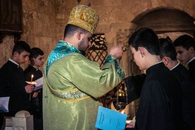 Kudüs, İsrail, 21 Şubat 2026 Katolik rahipler ve inananlar Kutsal Mezar 'ın karanlığında bir ayini kutluyorlar. Antik şehir tapınağındaki kutsal dua ve inanç atmosferi.