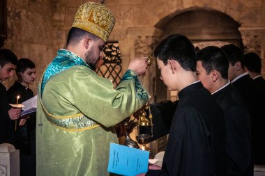 Kudüs, İsrail, 21 Şubat 2026 Katolik rahipler ve inananlar Kutsal Mezar 'ın karanlığında bir ayini kutluyorlar. Antik şehir tapınağındaki kutsal dua ve inanç atmosferi.