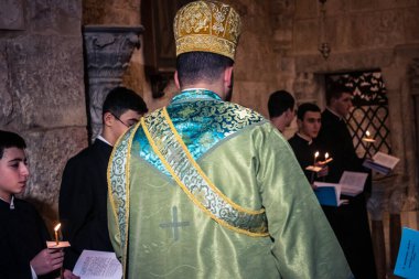 Kudüs, İsrail, 21 Şubat 2026 Katolik rahipler ve inananlar Kutsal Mezar 'ın karanlığında bir ayini kutluyorlar. Antik şehir tapınağındaki kutsal dua ve inanç atmosferi.