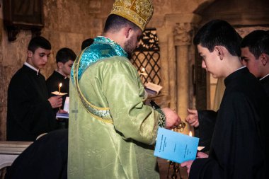 Kudüs, İsrail, 21 Şubat 2026 Katolik rahipler ve inananlar Kutsal Mezar 'ın karanlığında bir ayini kutluyorlar. Antik şehir tapınağındaki kutsal dua ve inanç atmosferi.