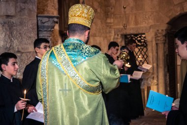 Kudüs, İsrail, 21 Şubat 2026 Katolik rahipler ve inananlar Kutsal Mezar 'ın karanlığında bir ayini kutluyorlar. Antik şehir tapınağındaki kutsal dua ve inanç atmosferi.