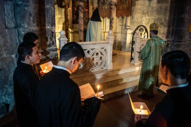 Kudüs, İsrail, 21 Şubat 2026 Katolik rahipler ve inananlar Kutsal Mezar 'ın karanlığında bir ayini kutluyorlar. Antik şehir tapınağındaki kutsal dua ve inanç atmosferi.