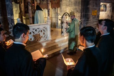 Kudüs, İsrail, 21 Şubat 2026 Katolik rahipler ve inananlar Kutsal Mezar 'ın karanlığında bir ayini kutluyorlar. Antik şehir tapınağındaki kutsal dua ve inanç atmosferi.