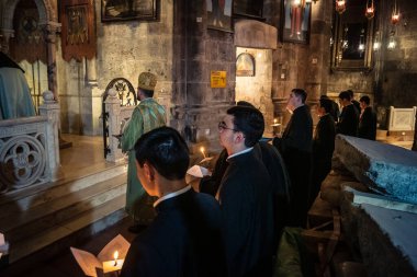 Kudüs, İsrail, 21 Şubat 2026 Katolik rahipler ve inananlar Kutsal Mezar 'ın karanlığında bir ayini kutluyorlar. Antik şehir tapınağındaki kutsal dua ve inanç atmosferi.